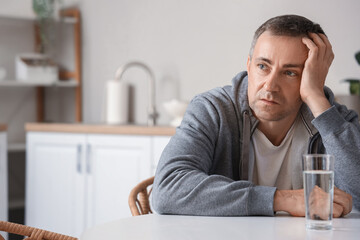 Fototapeta premium Mature man having panic attack in kitchen