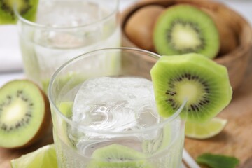 Refreshing drink with kiwi on table, closeup