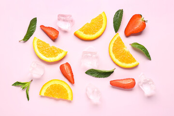Orange slices with strawberries, ice cubes and mint on pink background