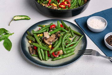 Plate with different vegetables on light background