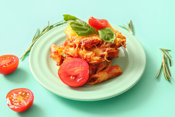 Plate of pasta with tomato sauce and cheese on turquoise background