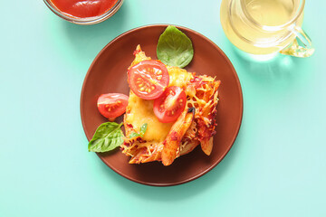 Plate of pasta with tomato sauce and cheese on turquoise background