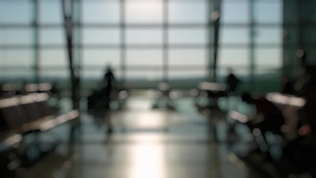 Defocused Silhouettes of passengers waiting and walking in front of the boarding gates at Izmir Airport.