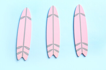 Mini pink surfboards on blue background