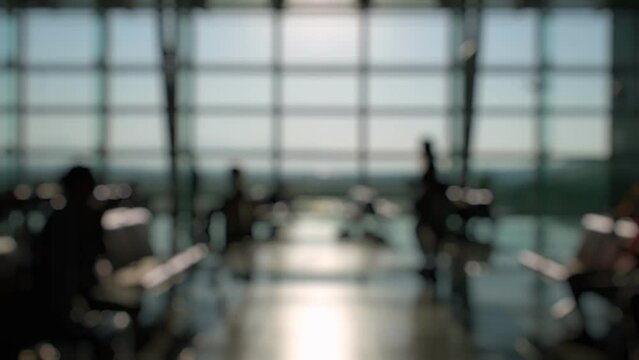 Defocused Silhouettes of passengers waiting and walking in front of the boarding gates at Izmir Airport.