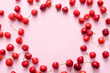 Frame made of sweet cherries on pink background