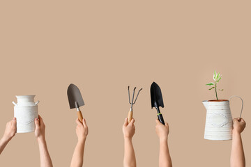People with gardening tools and plant on beige background