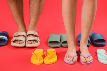 Legs of people and many flip-flops on red background