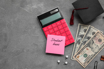 Sticky note with text STUDENT LOANS, calculator, graduation cap, stationery and dollar banknotes on grey background
