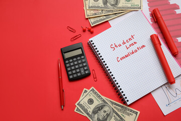 Notebook with text STUDENT LOAN CONSOLIDATION, calculator, dollar banknotes and stationery on red background