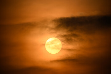 The sun moves towards the horizon. Occasionally obscured by dark clouds. Fugui Cape Lighthouse is known for its sunset shots and tourist attractions.