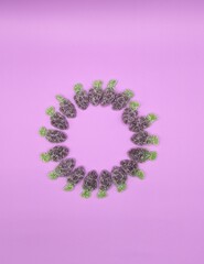 Round composition of grape gummies on purple background