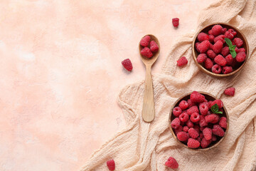 Bowls with fresh raspberry and mint on beige background