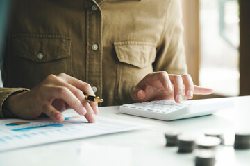 Accountant using calculator for calculate finance report in office.