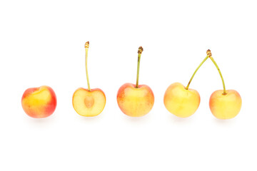 Sweet yellow cherries with half on white background