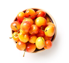 Bowl with sweet yellow cherries on white background