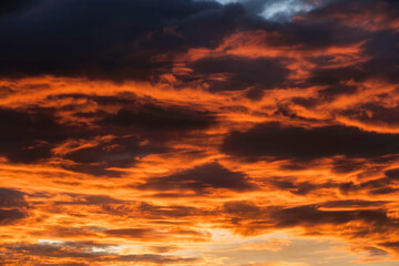 Beautiful landscape of sunset with dark colorful fluffy clouds. Natural background.