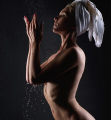 Slim nude blonde having shower in the dark