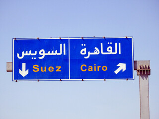 A road sign board before Suez Cairo highway gives the direction to the city of Cairo and Suez...
