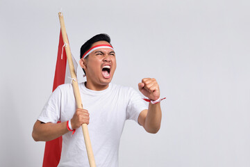 Excited young Asian men celebrate Indonesian independence day on 17 August by holding the Indonesian flag isolated over white background