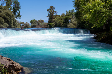 Manavgat waterfall Manavgat River is near the city of Side, 3 km north of Manavgat in Turkey. A wide stream of water falls from a low height.