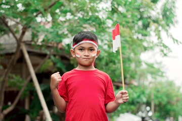 happy indonesian kid with flag at outdoor