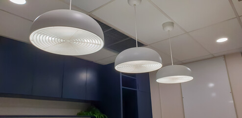 Ceiling with round modern lamps. Suspended fluorescent lights under the ceiling. Careful energy...
