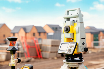 Surveyor builder site engineer with theodolite total station at construction site outdoors during...