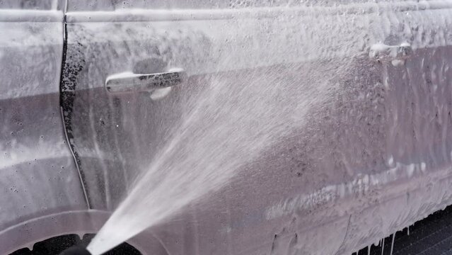 Washing a car with white foam. High pressure lance that spreads foam. Wash gun snow foam lance