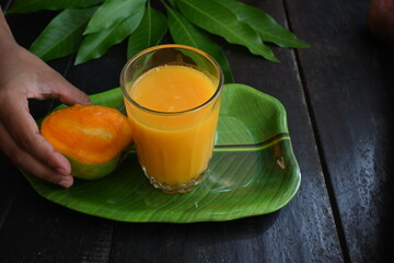 Mango juice with mango slice isolated on black background. Mango shake. Glass of  Fresh mango juice. This is a traditional and most popular drink of Indian in summer.