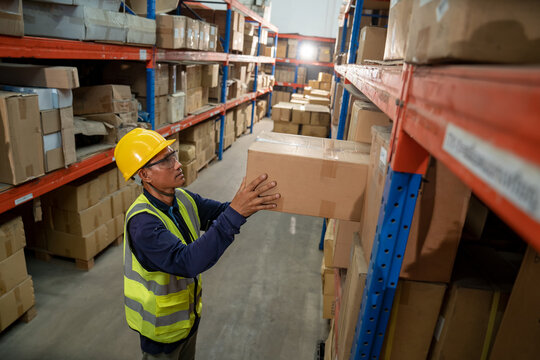 warehouse A distribution center worker carries the box and prepares it for delivery.