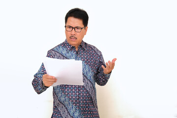 Asian lecturer holding his student assignment paper with unhappy facial expression