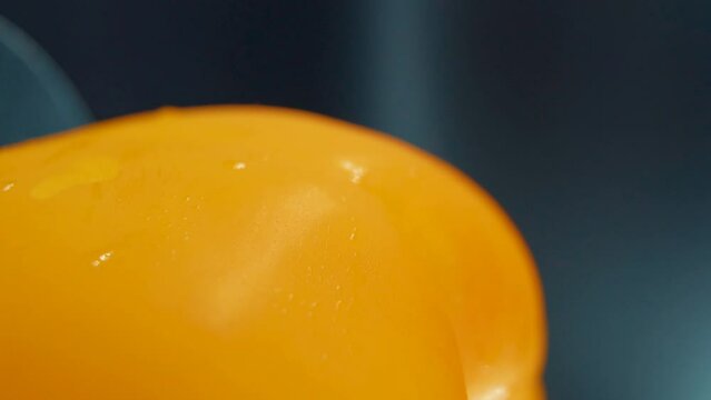 A vertical macro close up detailed shot of a wet sweet yellow pepper on a rotating stand, shiny sweaty water drops, cinematic studio lighting, super slow motion, 120 fps, smooth movement, Full HD
