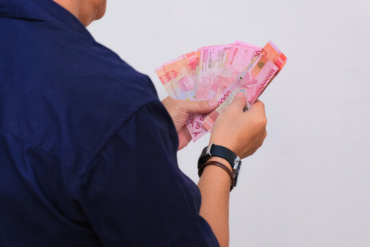Closeup shot of man holding some rupiah money in his hands