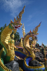 Fototapeta premium Group of beautiful statues of Buddha images, angels and Nagas at Wat Don Khanak Temple in order for religious people to travel to pay homage to the holy things. Located at Nakhon Pathom in Thailand.