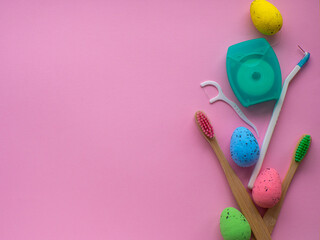 Happy Easter and dentist concept. Wooden toothbrushes with Easter decorations on pink background....