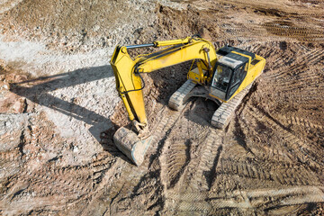 A powerful crawler excavator is working on a construction site. Close-up. View from above. Preparation of a pit for construction. Excavation.