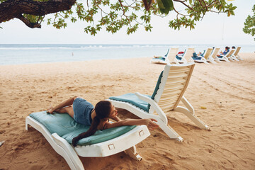 Fototapeta na wymiar woman smiling lying sunbed sea resort rest beach sand lifestyle ocean