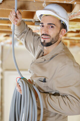 portrait of tradesman holding reel of cable