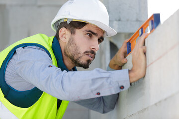 man builder measures the level of a wall