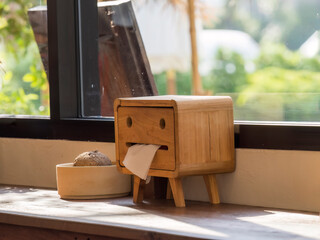 Natural Elegance: Wooden Tissue Box Adorned by Sunlit Window