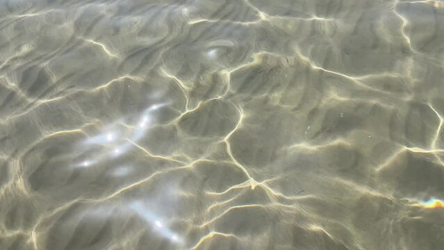 Beautiful water surface, the waves shimmer in the sun. Abstract background
