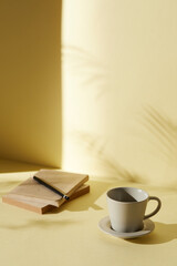 A room with various objects such as warm sunlight, shadows of grass leaves, a vase on a table, and cups