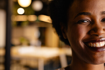 Half portrait of happy african american casual businesswoman with afro in office, copy space