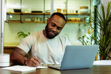 Happy African Male Working at Home Desk with Laptop
