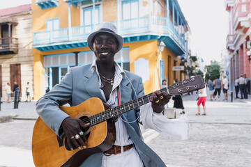 Black Man musician playing guitar on the street in La Havana in Latin America, Afro american and...