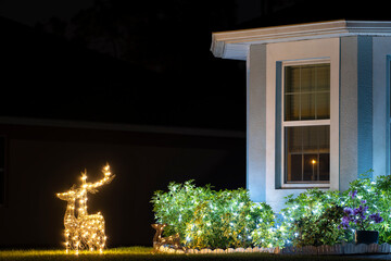 Brightly illuminated christmas decorations on front yard of florida family home. Outside decor for...