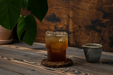 Refreshing espresso tonic cold coffee drink in a glass with ice cubes, on wooden background
