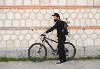 Fototapeta na wymiar Man Skateboarder with a bike Lifestyle Hipster Concept
