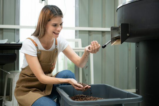 Portrait of a young woman working with a coffee roaster machine